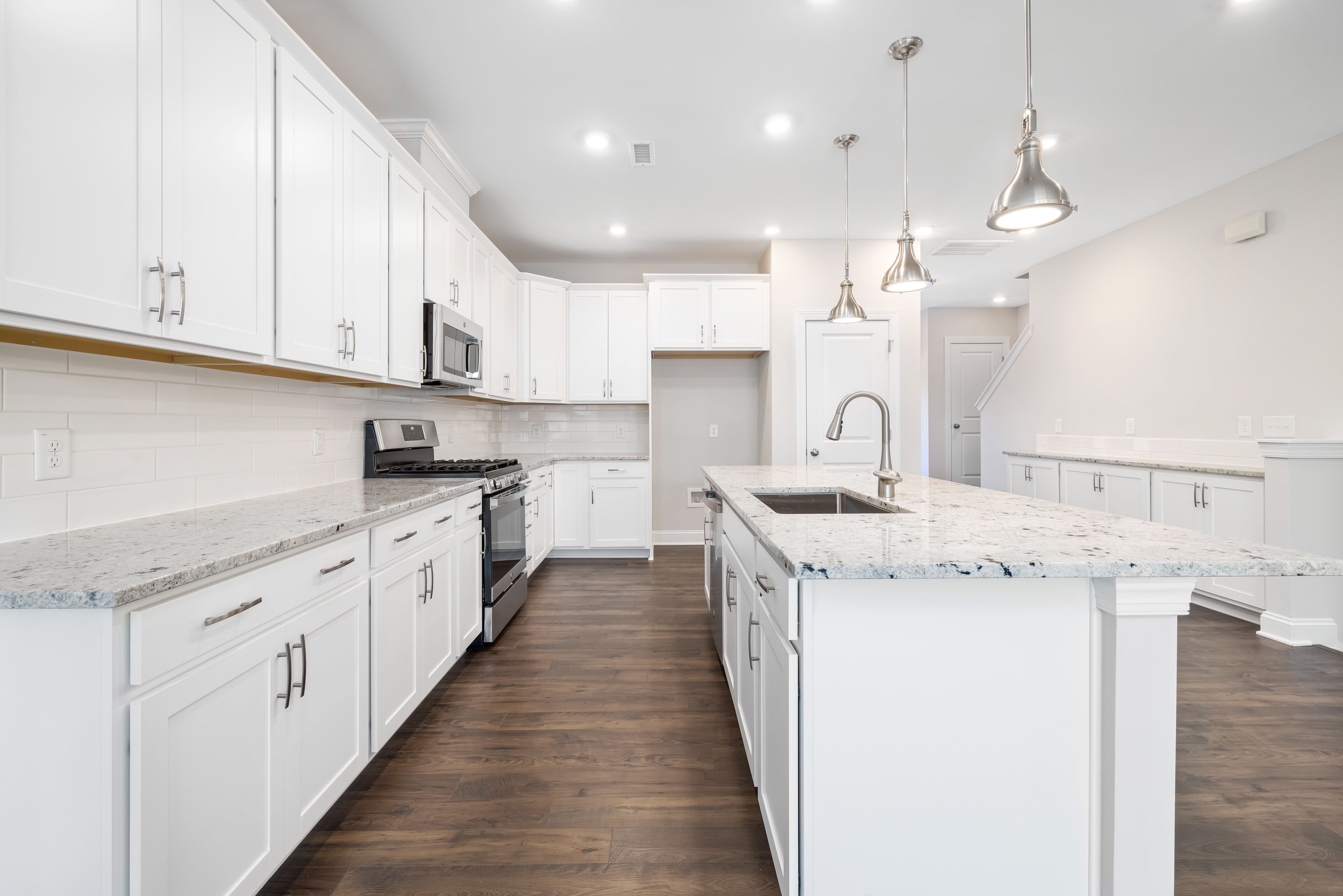 Kitchen inspiration with white cabinets and wood flooring